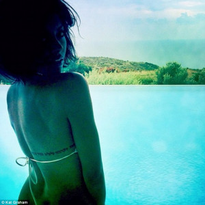 Feeling sultry: In another shot, she displays her back tattoo as she ...