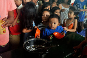 PLEA FOR AID. Children wait for their food rations in Malanday ...