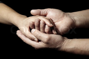 ... 'Hands of senior people supporting each other on a black background