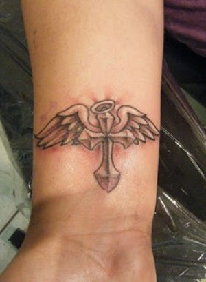Small cross tattoo on Ryans wrist