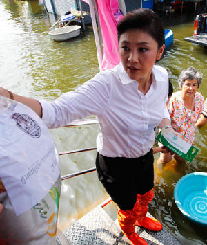 Thailand's Prime Minister Yingluck Shinawatra distributes food to ...