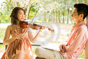 woman-playing-violin-her-boyfriend-young-women-garden-31378547.jpg