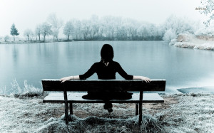 Girl sitting on a frosty lakeside bench wallpaper