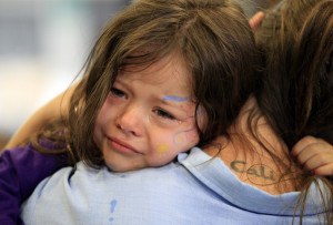 Cali Farmer, 4, (L) cries as she hugs her mother Netta Farmer at ...
