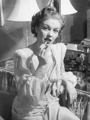 Woman Sitting at Vanity Table, Putting on Lipstick Photographic Print