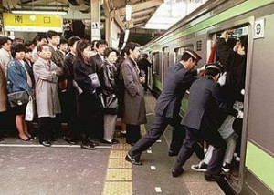 日本の 満員電車に 車掌さんが人を押し込む光景は