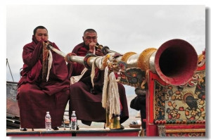 Two monks are playing Dungchen, a Tibetan instrument for playing ...