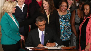 President Barack Obama is flanked by Lilly Ledbetter (L) and other ...