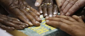 Hands of poll workers are seen on a Bible as head precinct judge ...