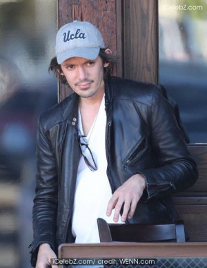 Lukas Haas playing chess with a friend a smoking cigars outside a bar ...