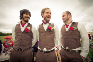 Gorgeous groomsmen in rustic brown suits and striking red buttonholes