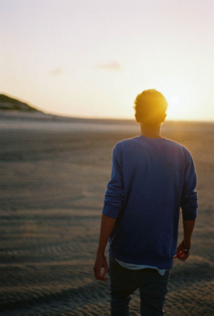 夕阳下,一对情侣手挽着手坐在花坛边看夕阳