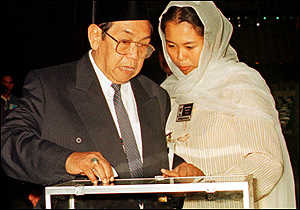 Abdurrahman Wahid casts his vote helped by his daughter Yenni
