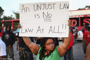 Demonstrators with signs on Monday show their outrage at the shooting ...