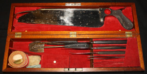Color photograph of an amputation box holding a variety of metal tools ...
