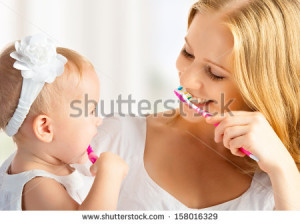 ... and daughter baby girl brushing their teeth together - stock photo