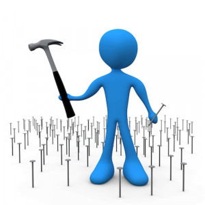 ... Hammer And Nail While Standing In A Patch Of Many Nails Clipart