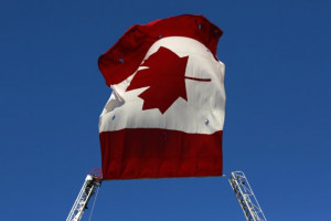 firefighter works to untangle a knot in a giant Canadian flag during ...