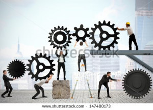 Teamwork works together to build a gear system - stock photo