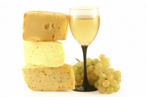Grapes, cheese and a glass with wine isolated on white.