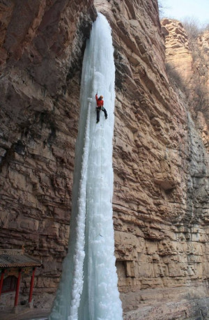 Badass guy climbing a frozen waterfall in China