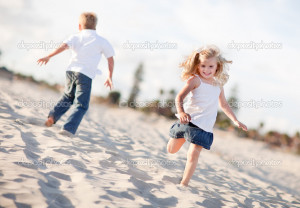 Adorable Brother and Sister Having Fun at the Beach - Stock Image