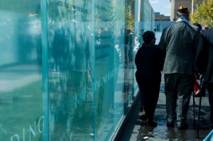 Veterans walk along glass panels with quotes from wounded warriors and ...