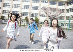 Japanese school children running out in the yard - stock photo