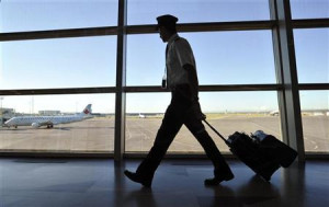 An Air Canada pilot walks to his plane at the International airport in ...
