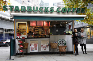 Customers leave a Starbucks coffee kiosk in the financial district of ...