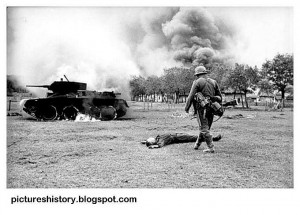 Russia. A German soldier walks over to inspect a destroyed Soviet tank