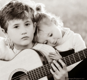 Kid couple romantic girl and boy hug playing guitar