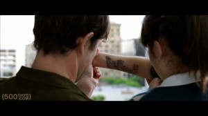 Drawing on Summer’s (Zooey Deschanel) arm