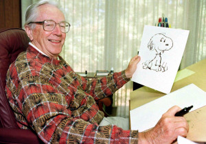 Charles M. Schulz with a drawing of Snoopy.