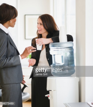 High-Res Stock Photography: Businesswomen talking by water cooler
