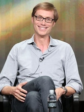 Stephen Merchant sits in a director's chair