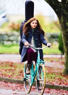 ... Mia (played by Chloe Grace Moretz) on her bicycle with her instrument