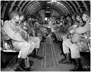 American paratroopers sit grimly on a plane to parachute into France