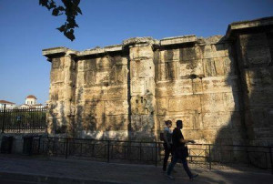 People walk in the early morning at the Plaka area in Athens, Greece ...