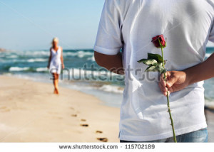 loving couple - man with rose waiting his woman on the sea beach at ...
