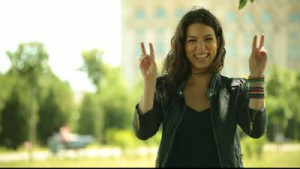 Excited adult pretty young woman air quotes and smiles.