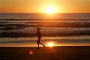 jogger runs along the shore of Manly Beach after sunrise on the ...