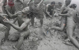 Tourists play with the mud during the 15th annual mud festival on ...