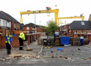 Belfast City Council workers remove a barricade from a street after ...