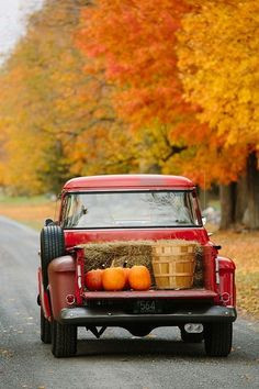 Vintage red truck hauling pumpkins, hay bales, and bushel baskets for ...