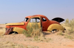 Old and rusty car wreck at the last gaz station before the Namib ...