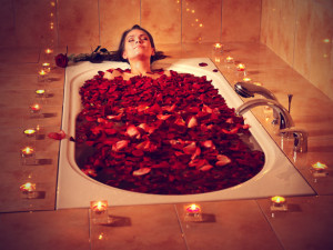 Woman relaxing in bath with rose petal