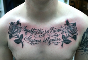 Imperfection Is Beauty - Quote And Flowers Chest Tattoo