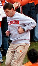 Coach Swinney in a grey sweatshirt and khaki pants, while running ...