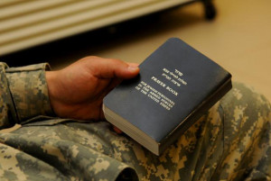 Soldier holds a Jewish prayer book before a Task Force Marne Jewish ...